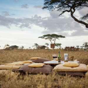 Luxury bush breakfast setup during Tanzania safari – outdoor table with view over savannah and acacia trees